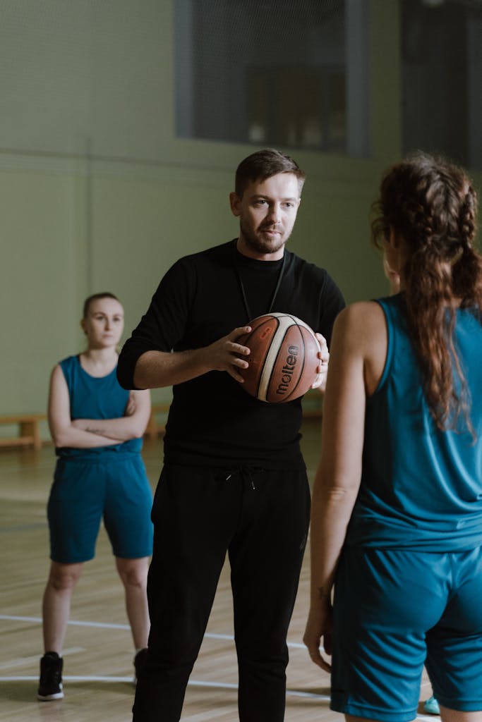 Man in Black Crew Neck Shirt Holding Basketball Beside Woman in Blue Tank Top